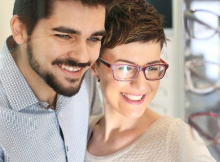 A smiling man and woman - the woman is wearing glasses